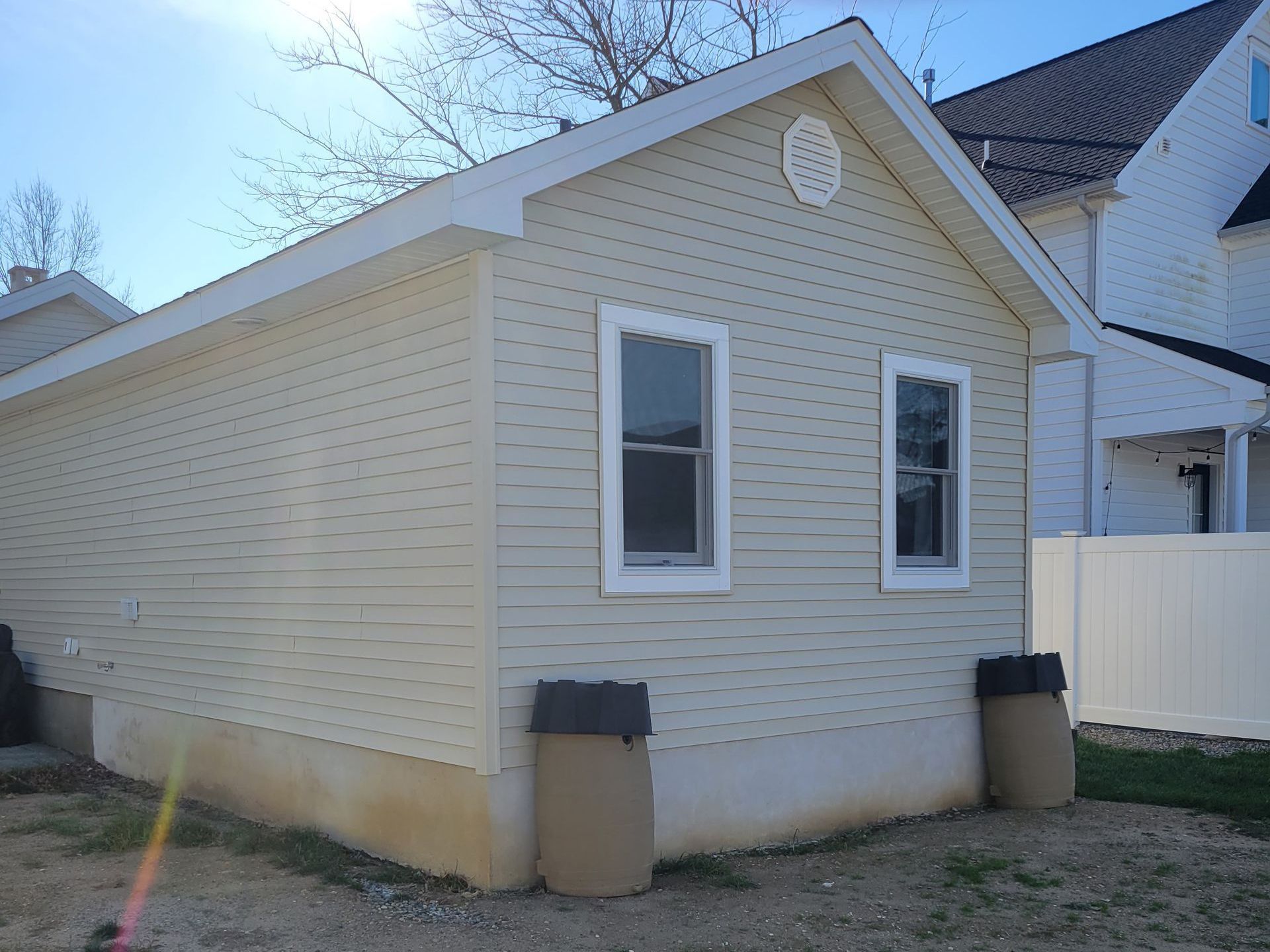 A small white house with two windows and a white fence