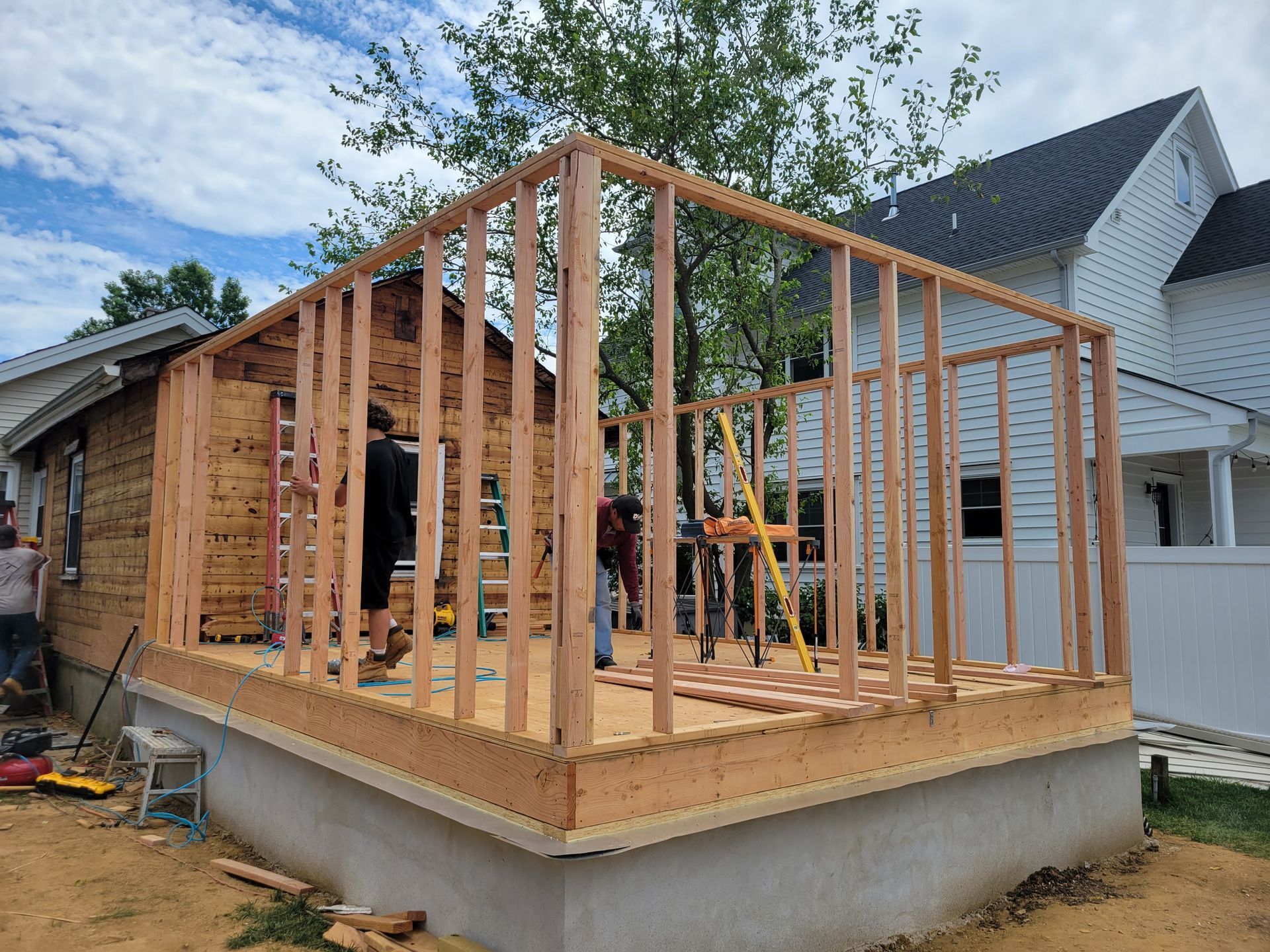 A wooden structure is being built in front of a house.