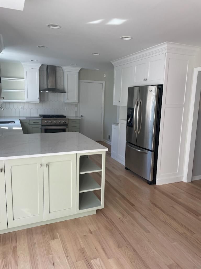 A kitchen with stainless steel appliances and white cabinets