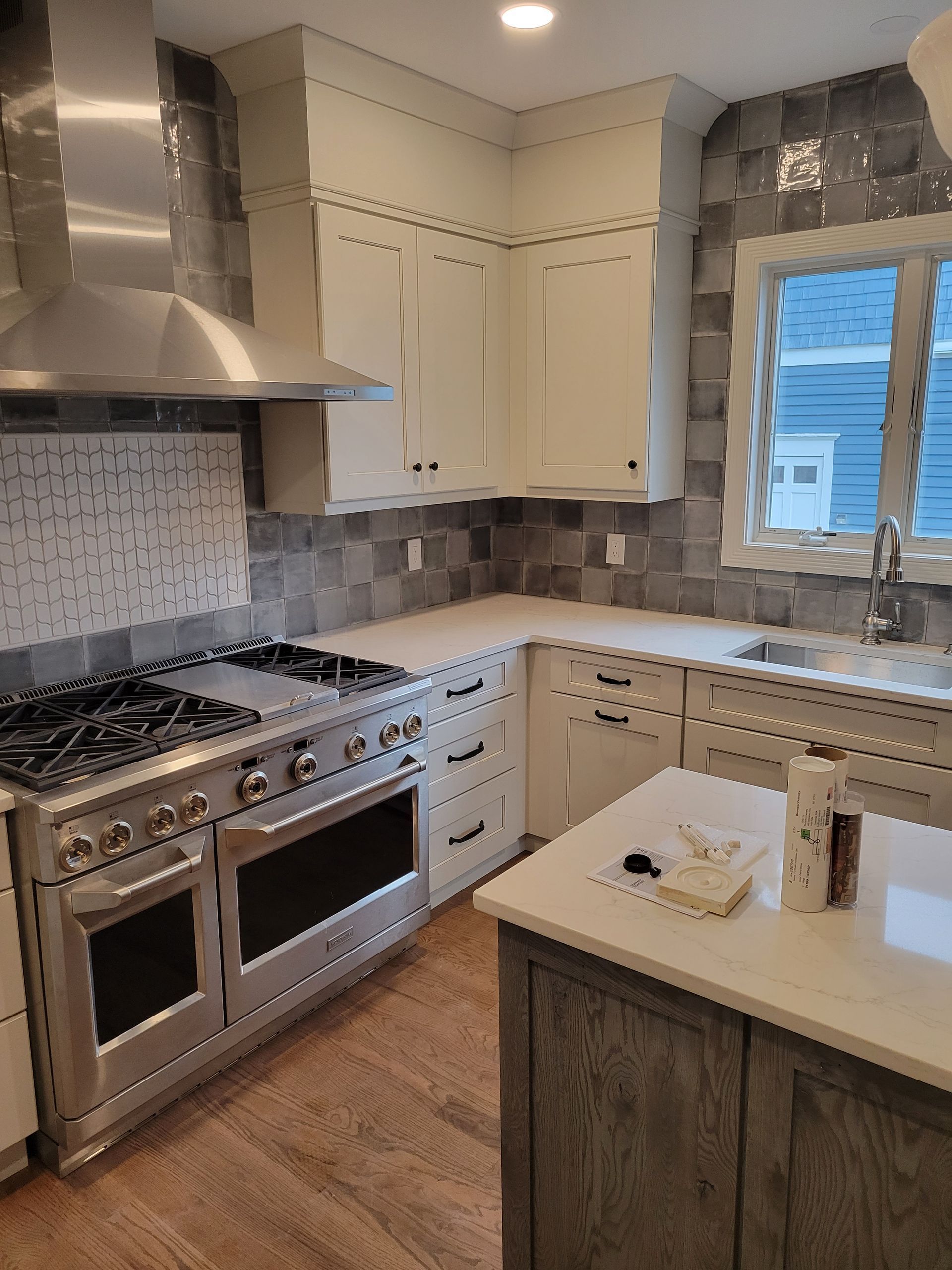 A kitchen with stainless steel appliances and white cabinets.