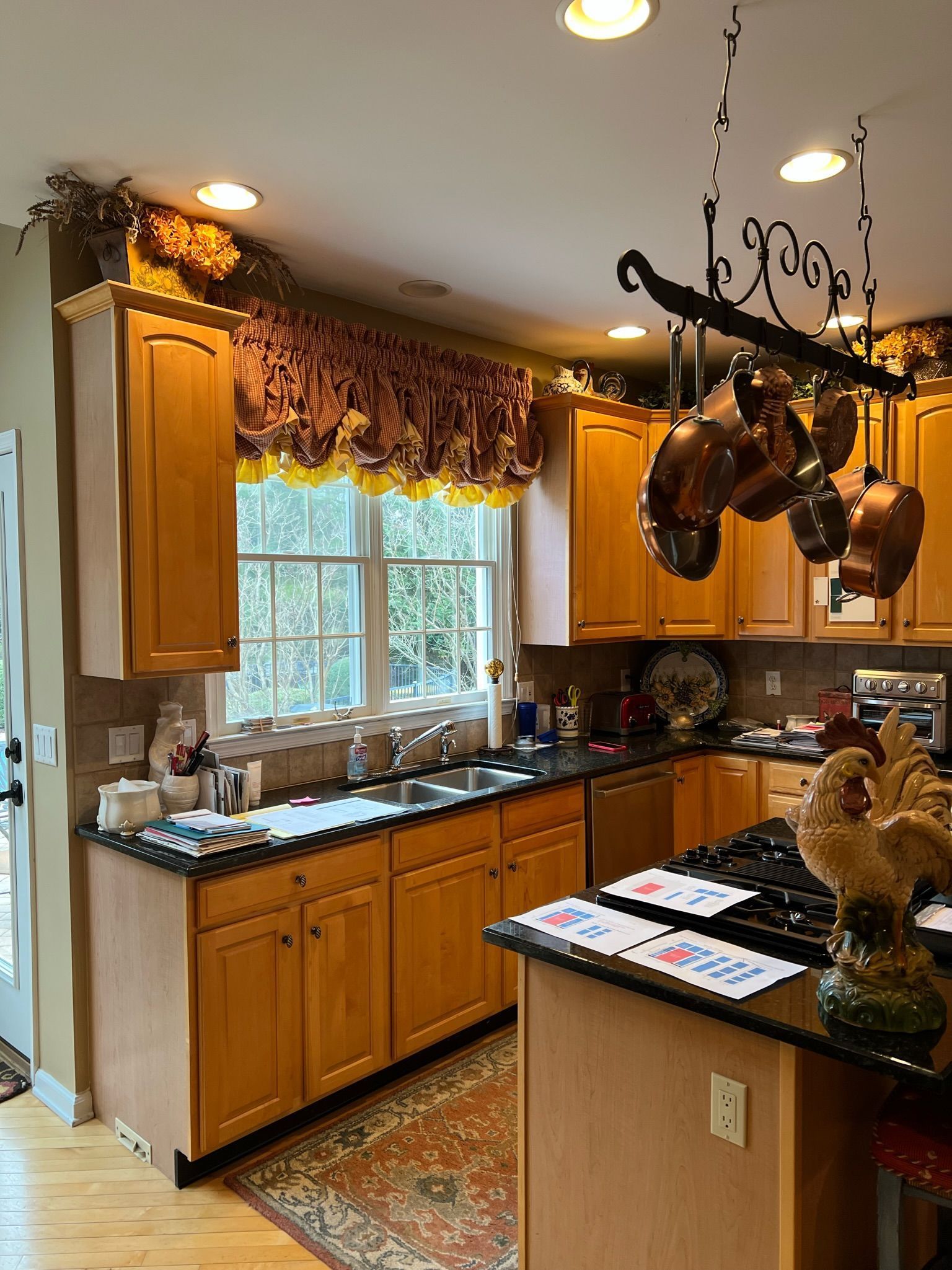 A kitchen with wooden cabinets and black counter tops