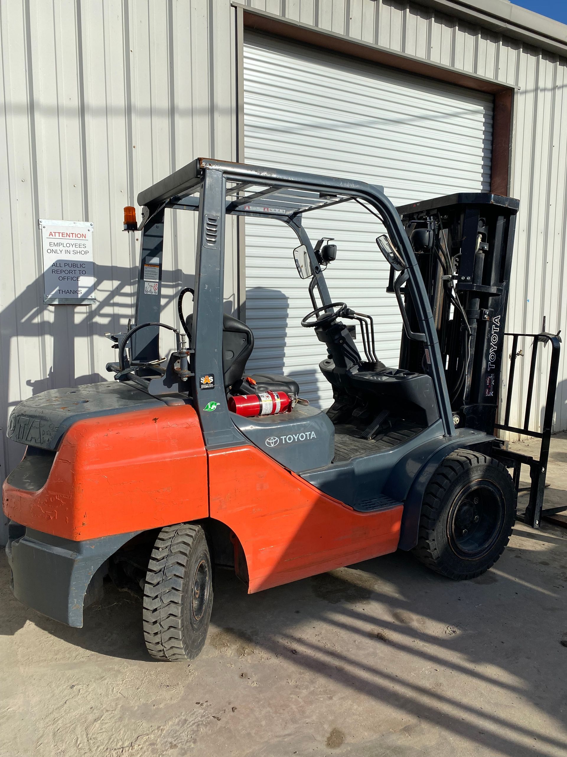 A forklift is parked in front of a building.