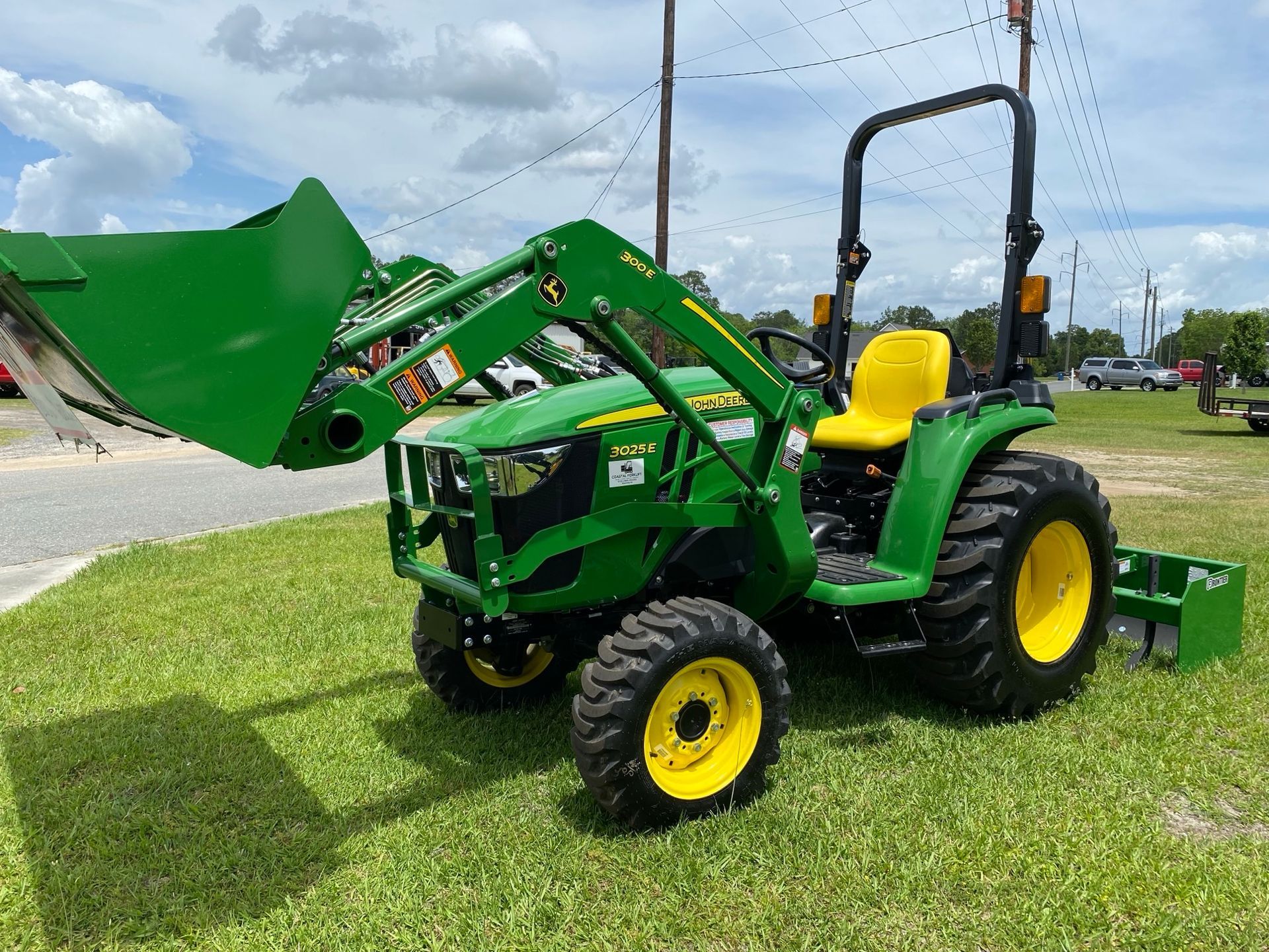 A green tractor with a yellow seat is parked in the grass.