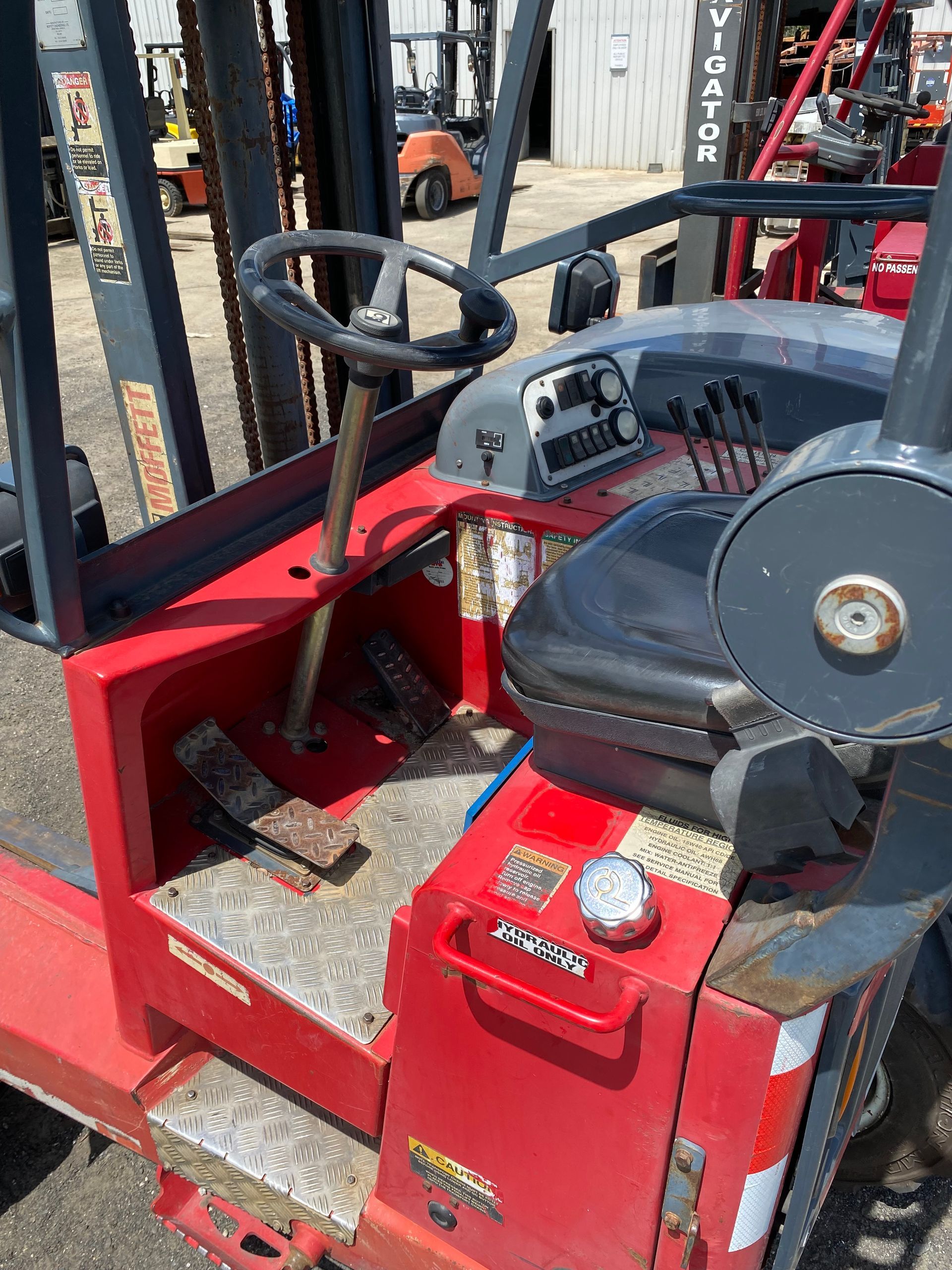 A red forklift is parked in a parking lot.