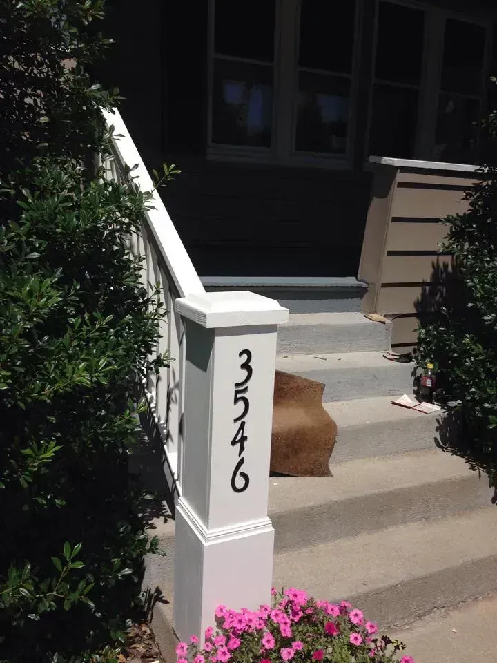 A house entrance with house number 3546 on a white post.