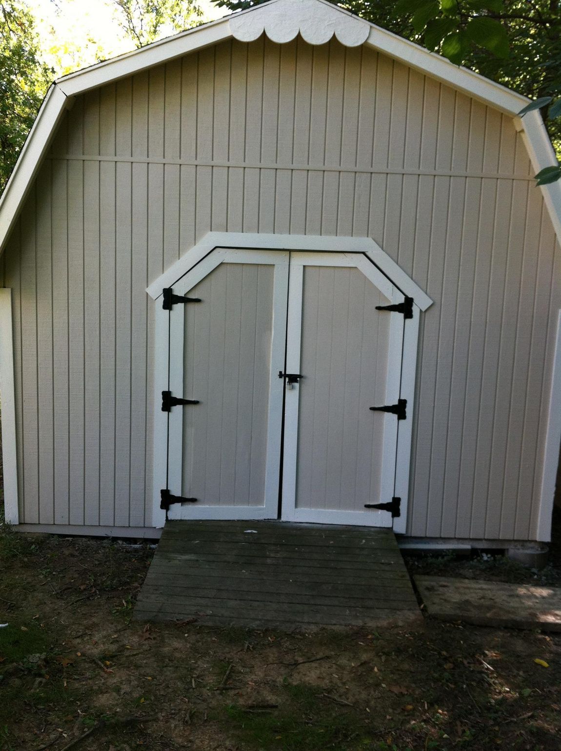 A white barn with black hinges on the doors