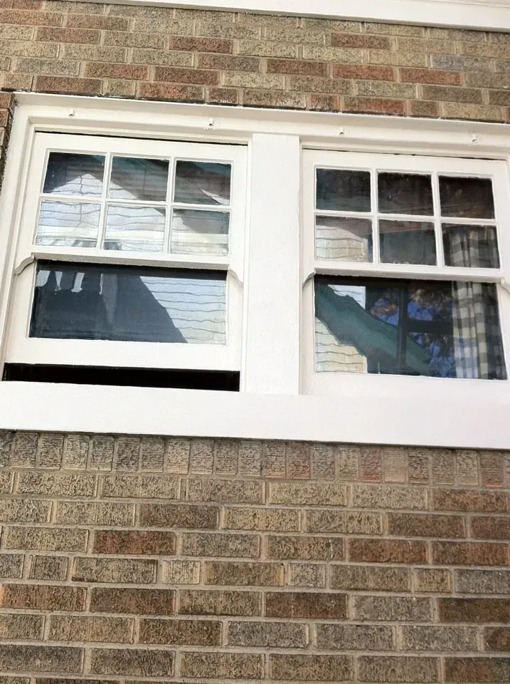A brick building with a white window on the side of it.