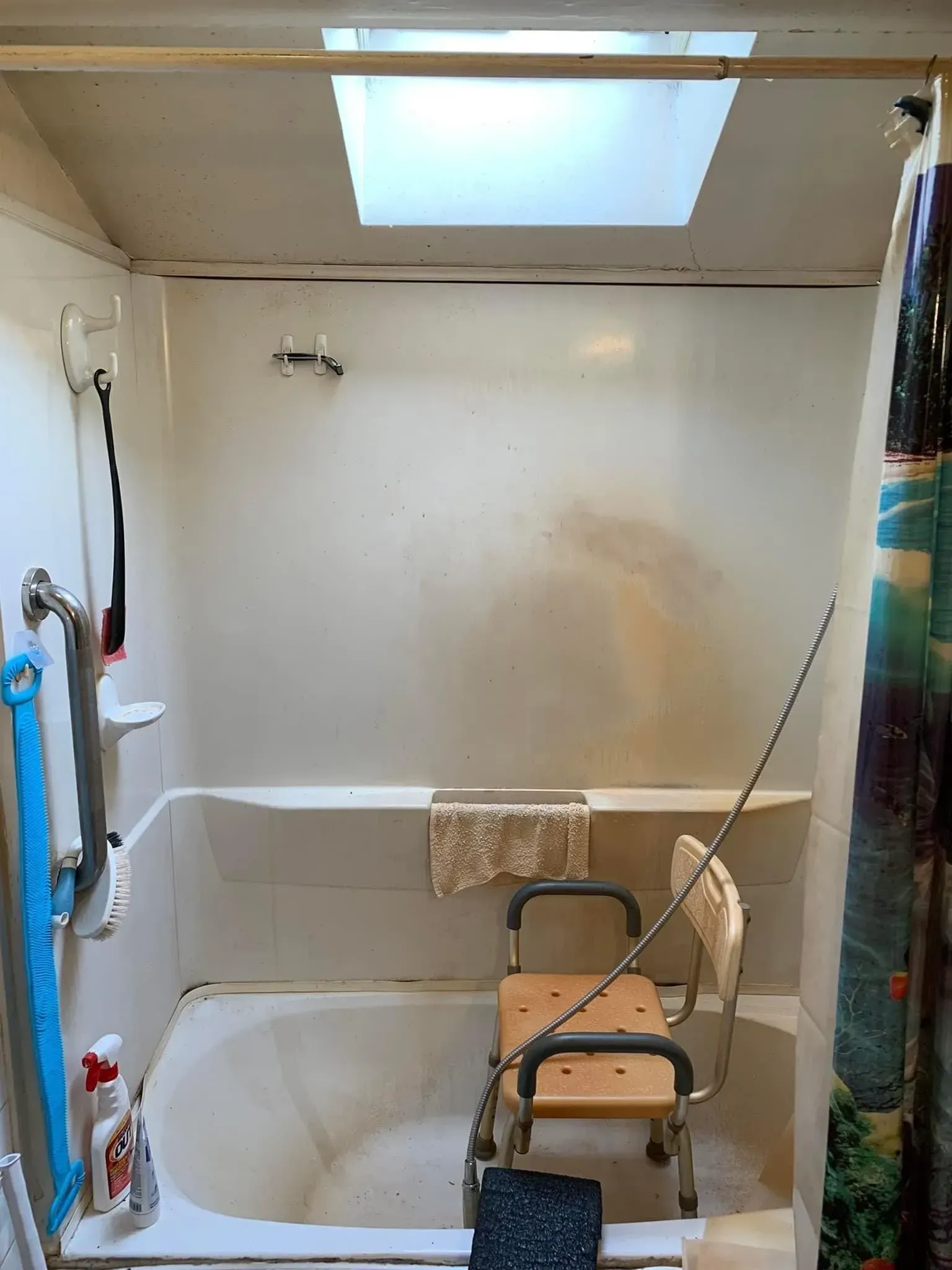 A bathroom with a bathtub and a chair in it.