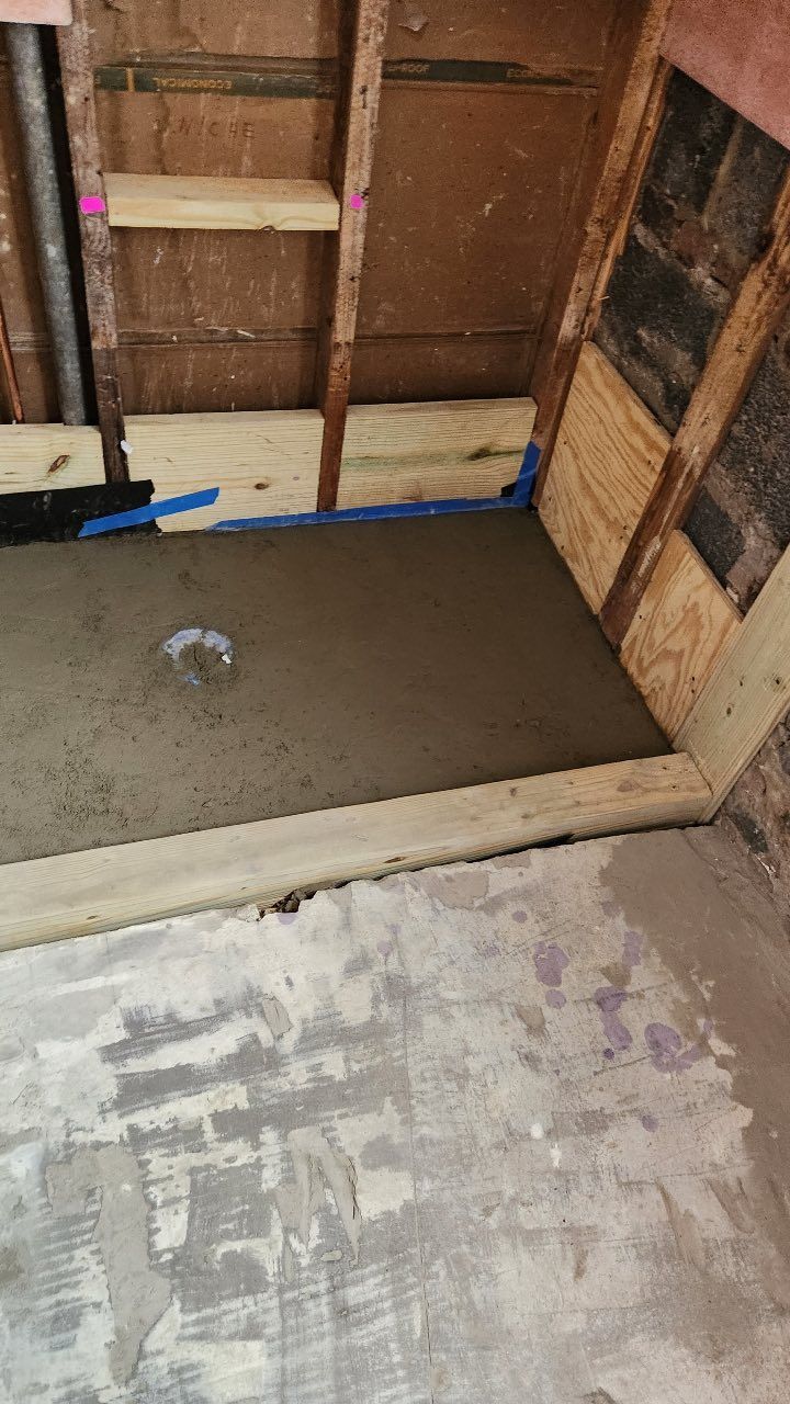 A room with a concrete floor and a wooden wall.