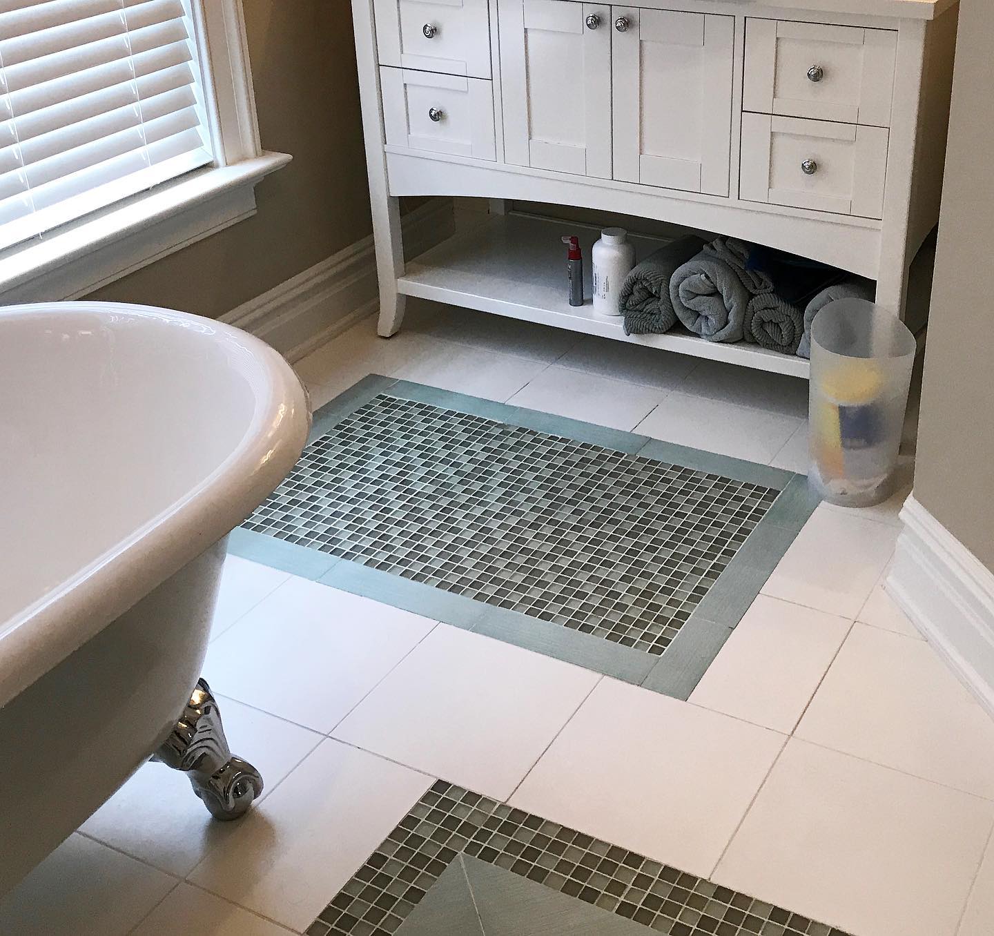 A bathroom with a claw foot tub and a white vanity