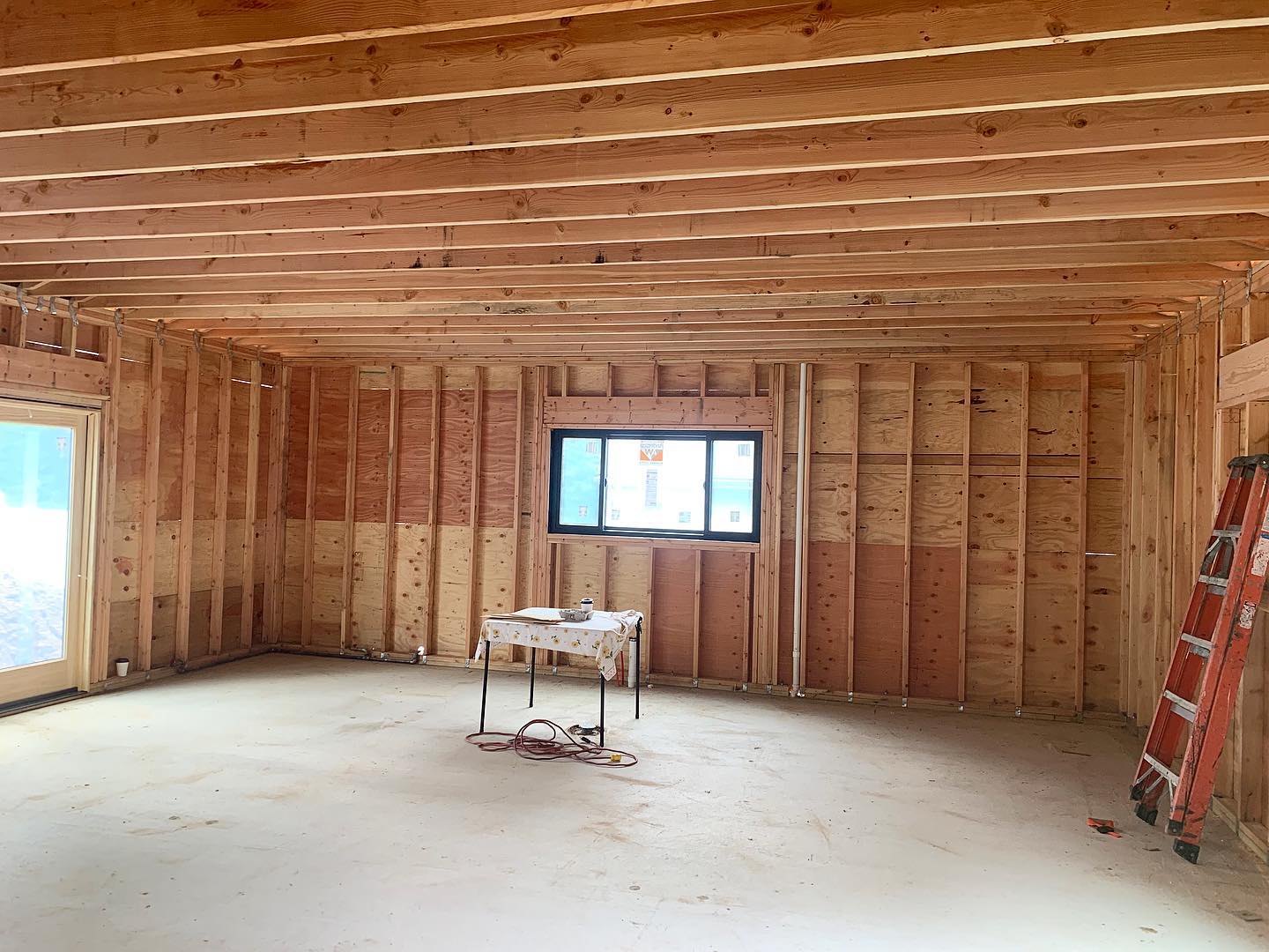 A room with a table and a ladder in it is being built.