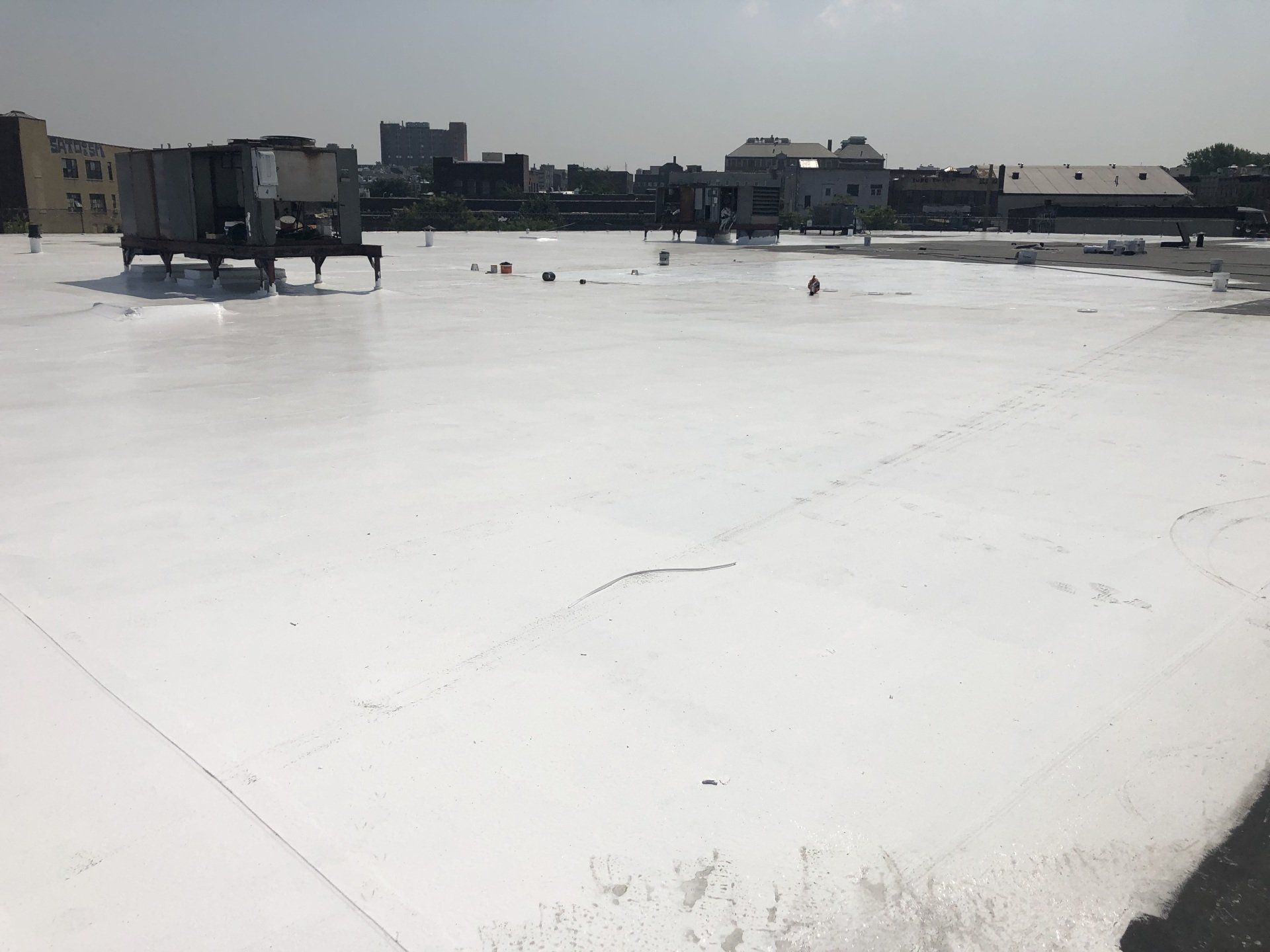 A large white roof with a lot of buildings in the background.