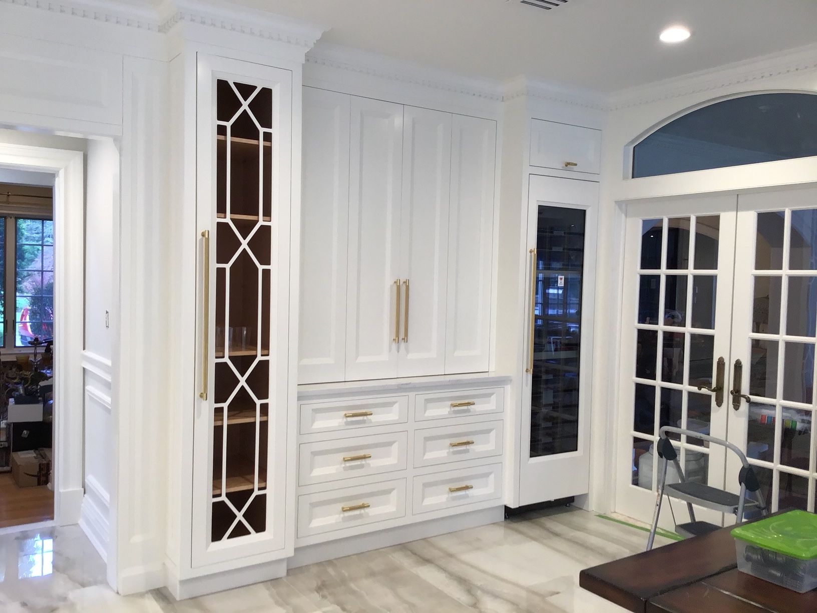 A kitchen with white cabinets and sliding glass doors.