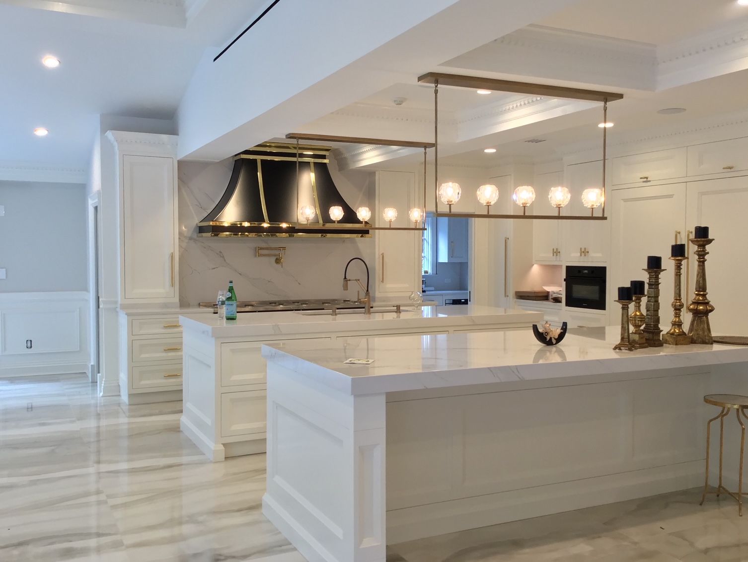 A kitchen with white cabinets and a large island