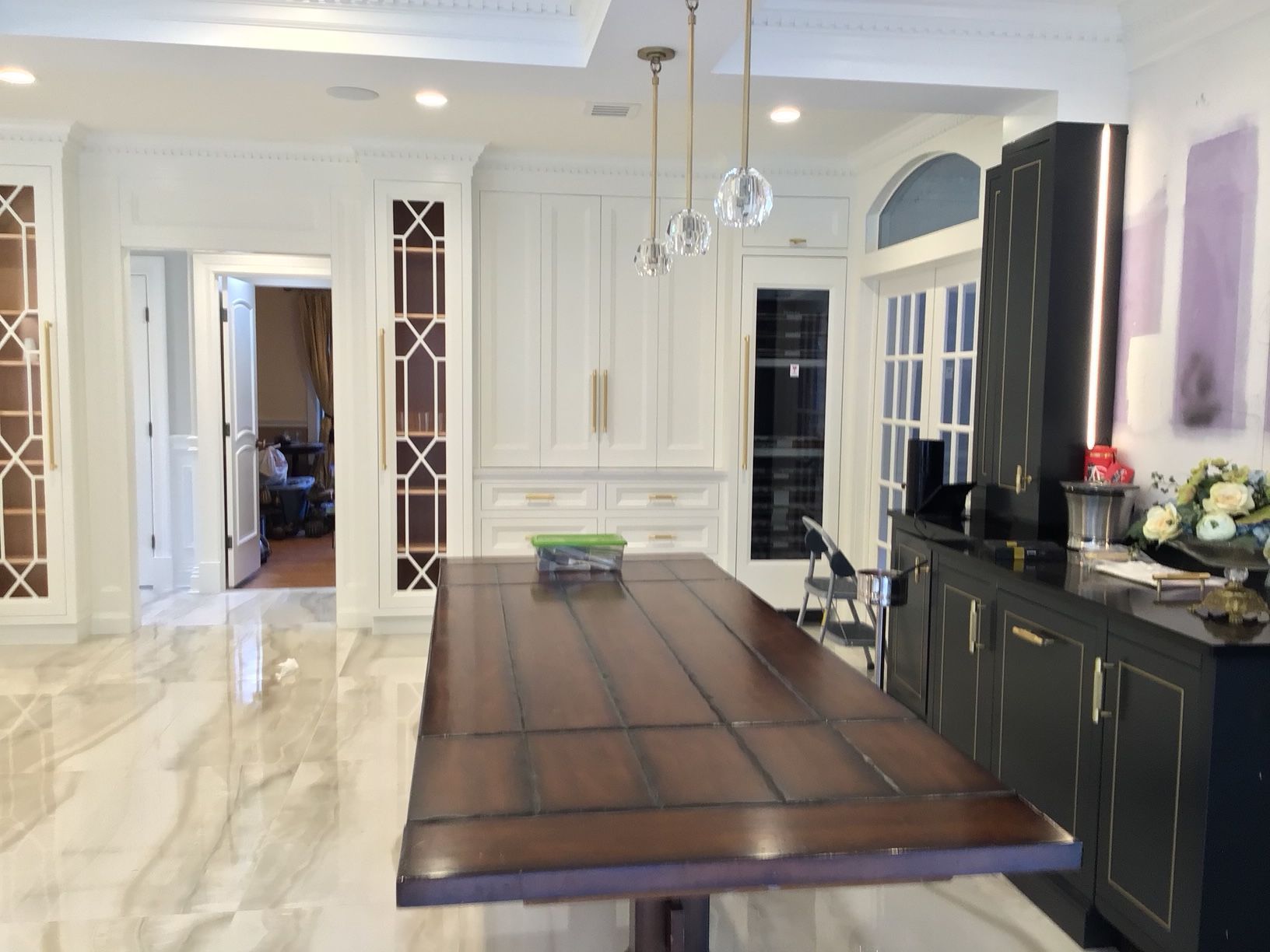 A kitchen with a large wooden table and black cabinets