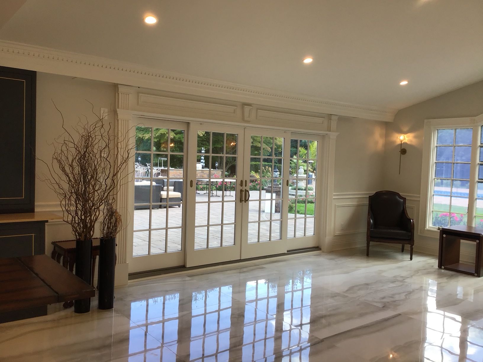 A living room with a lot of windows and sliding glass doors.