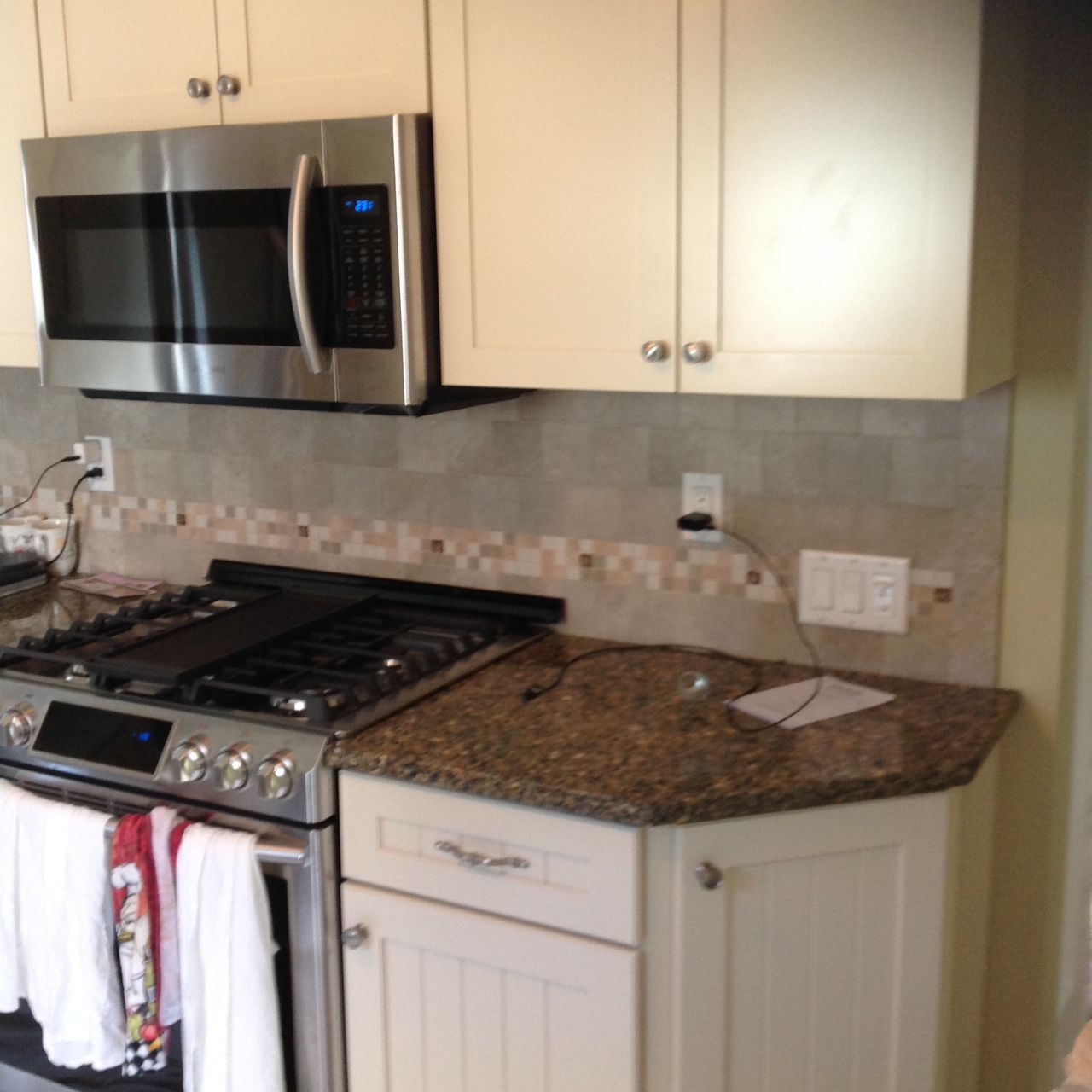 A kitchen with a stove top oven and a microwave