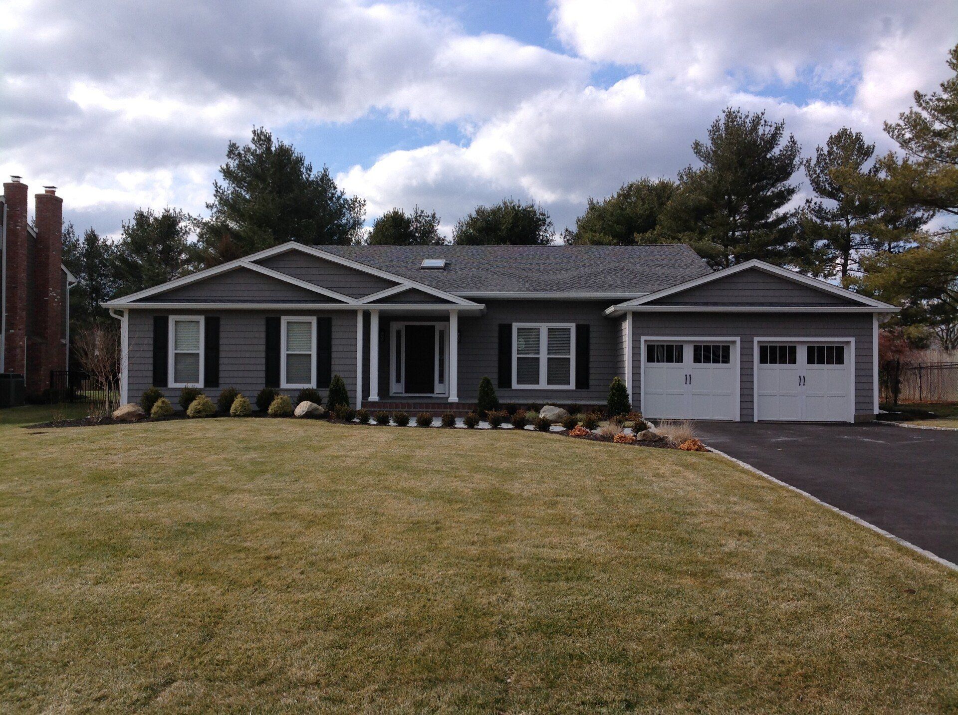 A gray house with two garage doors and a driveway