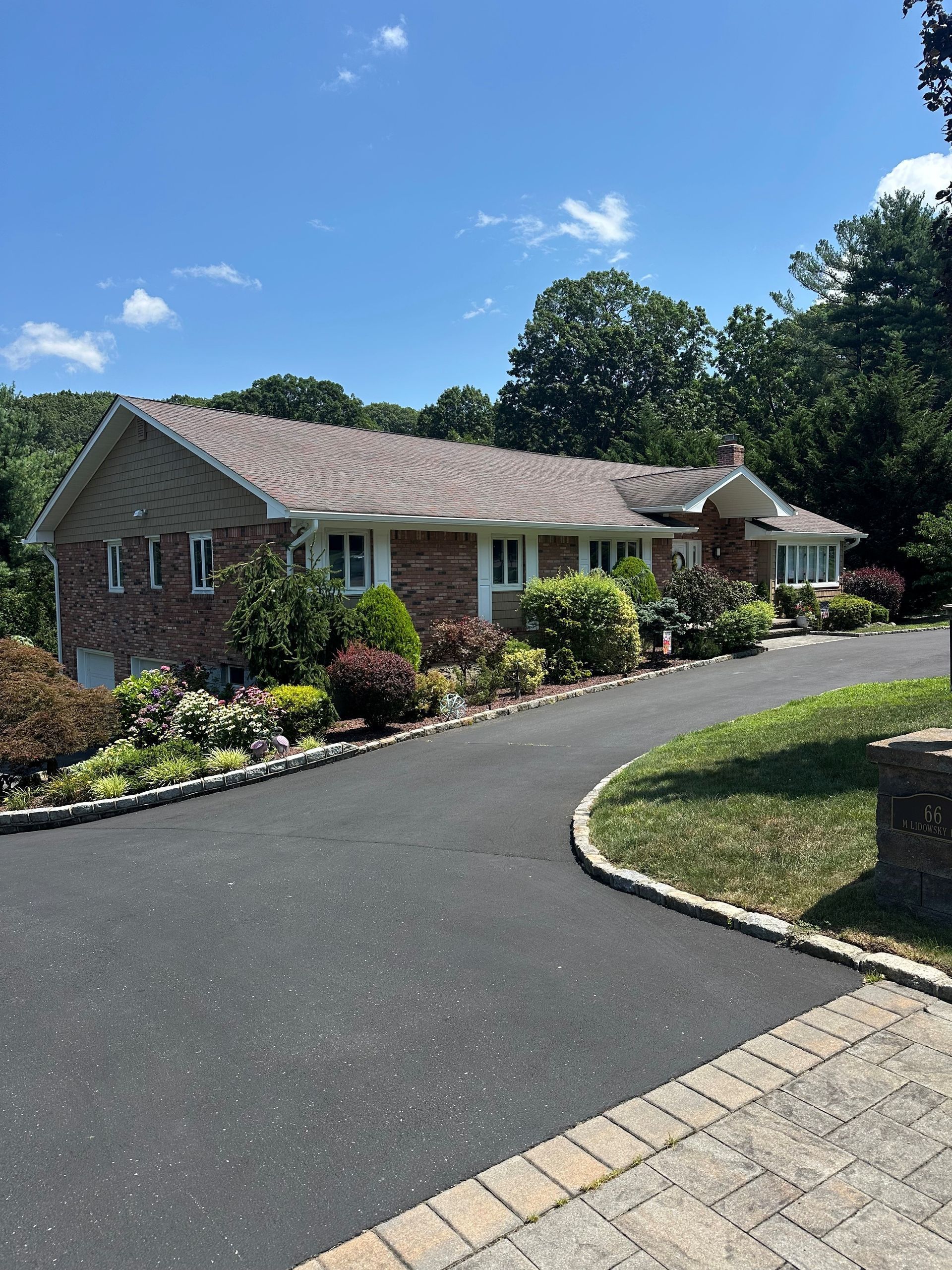 A large brick house with a driveway leading to it