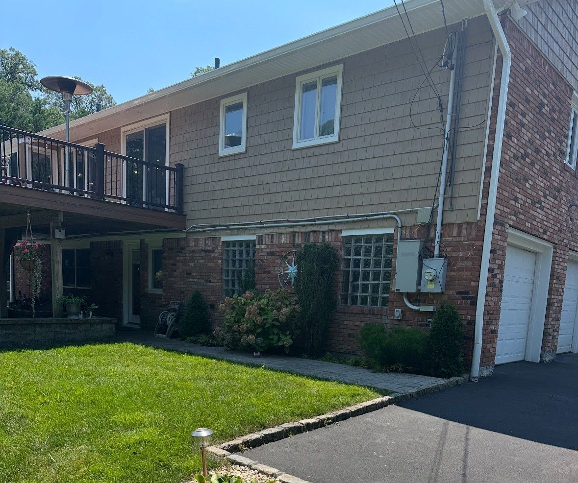 A large brick house with two garages and a deck