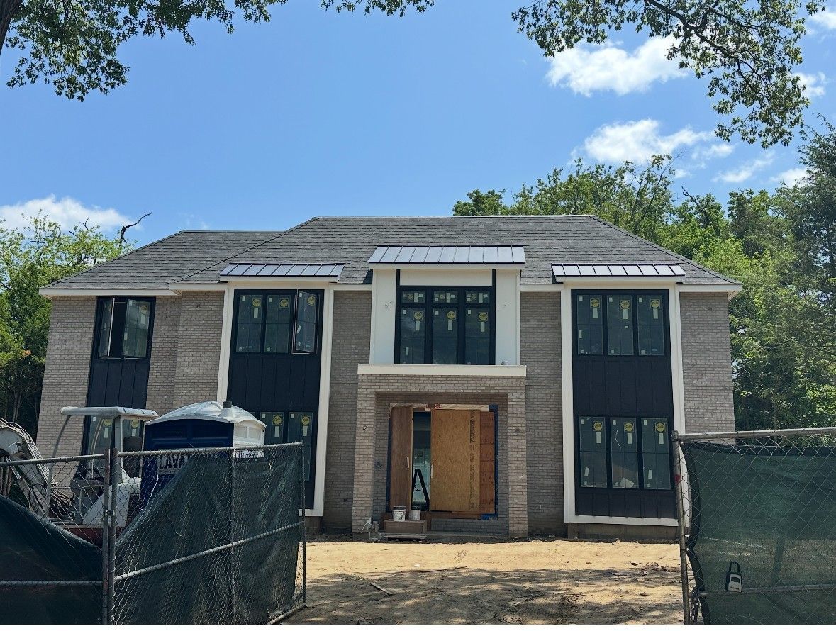 A large house under construction with a lot of windows