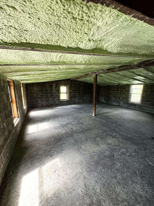 An empty room with a ceiling covered in green spray foam.