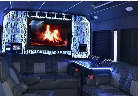 Modern media room with leather seating and a large screen showing a fireplace