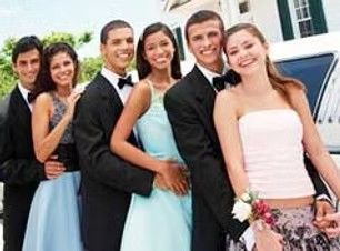 Group of five young people dressed formally, smiling and posing beside a white limousine outdoors
