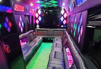 Neon-lit limousine interior with gray leather seating and colorful LED lights