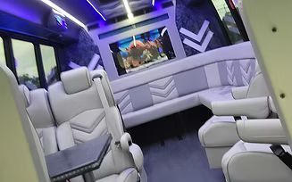 Luxury white interior with plush seats, blue lighting, and a wall-mounted fish tank