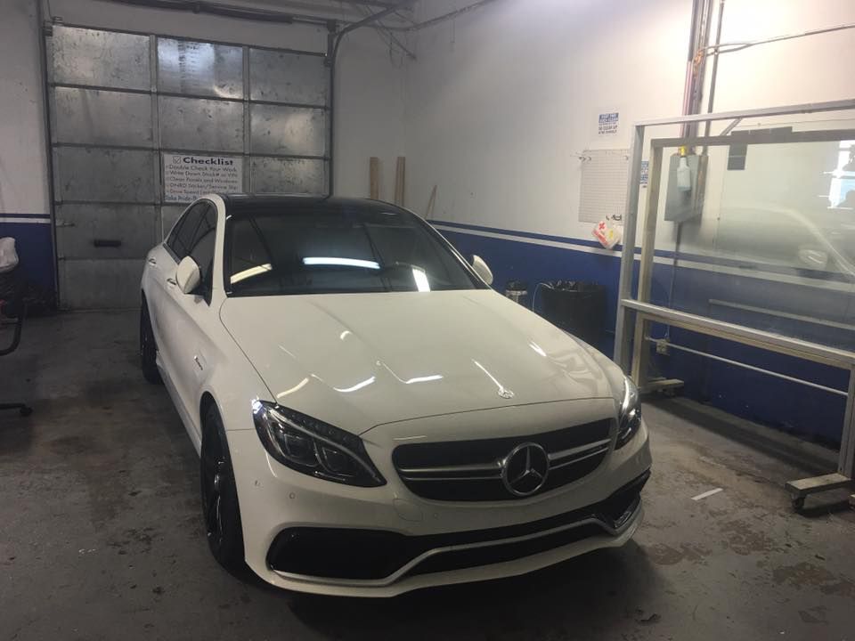 a white mercedes benz is parked in a garage