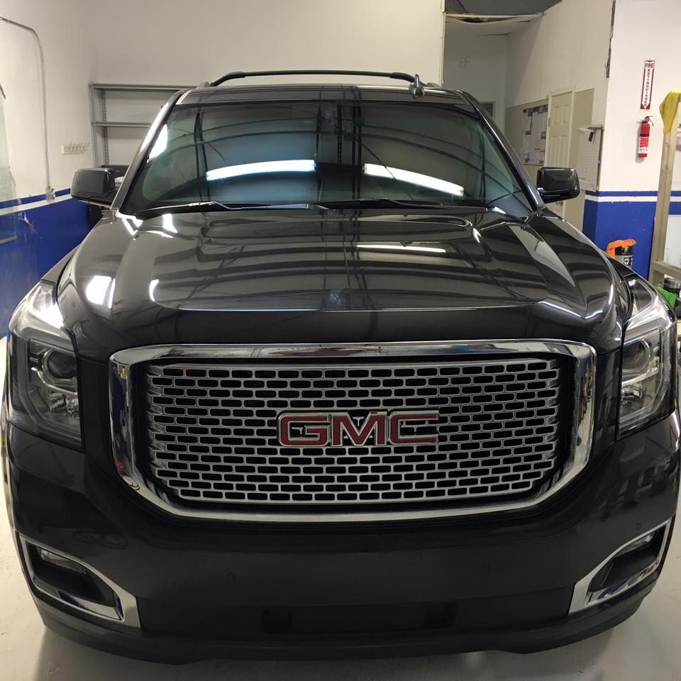 a black gmc suv is parked in a garage