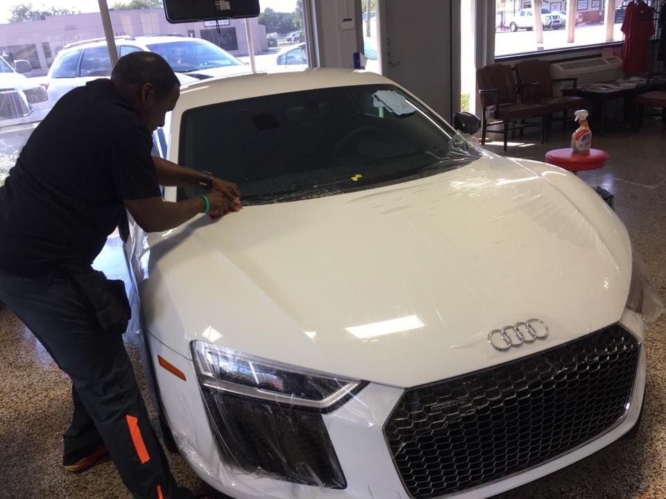 a man is working on a white audi car