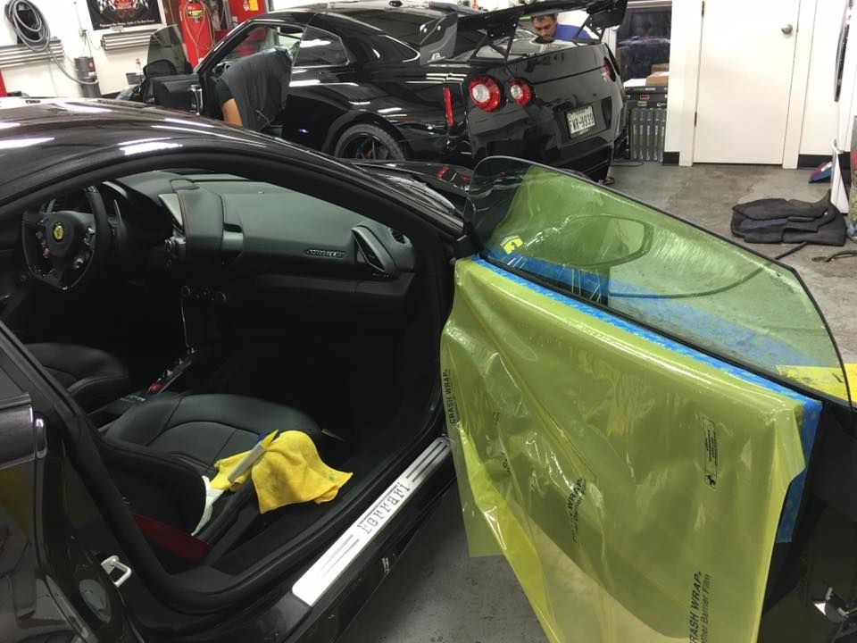 a man is working on a black car in a garage