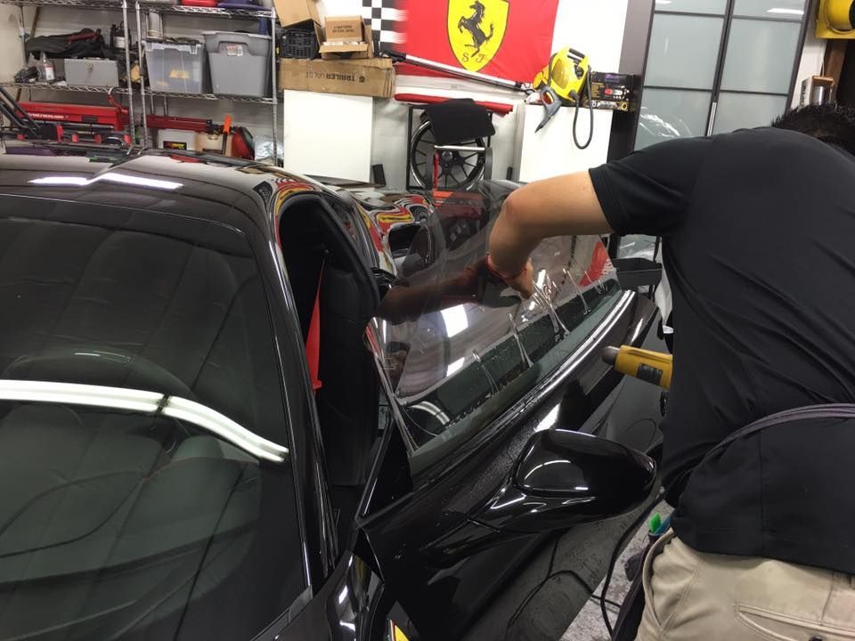 a man is working on a ferrari car in a garage