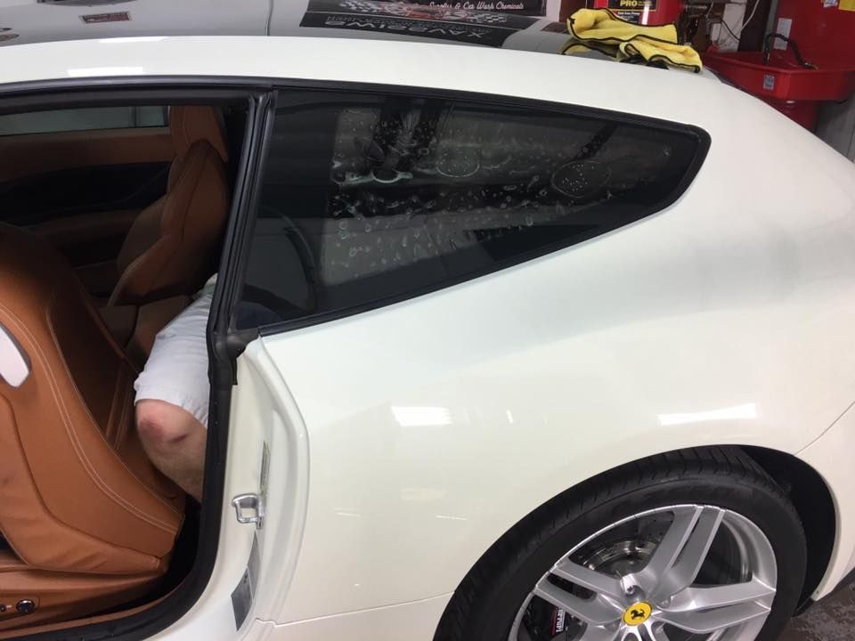 a person is sitting in the back seat of a white car