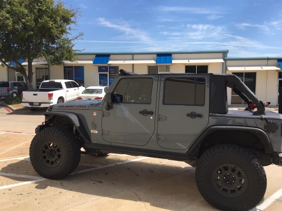 a jeep is parked in a parking lot in front of a building .