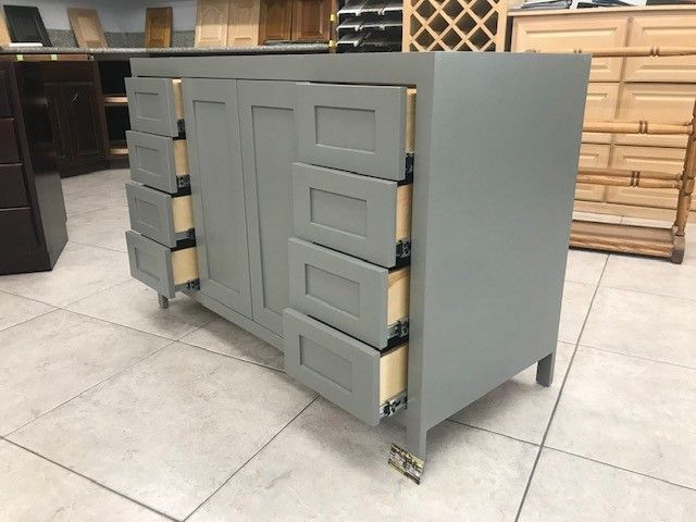 Gray cabinet with drawers and panel front on a workshop floor, shown at an angle