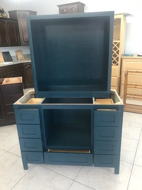 Blue dresser with a large mirror and multiple drawers in a room