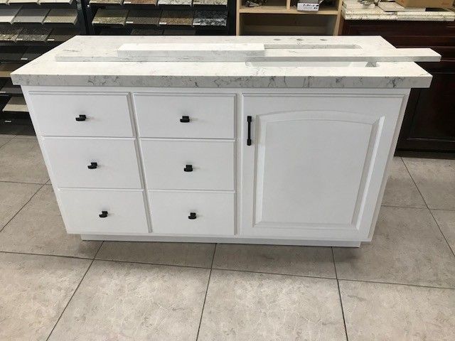 White kitchen island cabinet with drawers and a door on a tiled floor