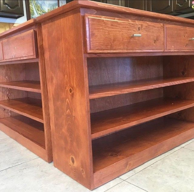 Wooden cabinet or shelving unit with open shelves and drawers, shown outdoors on a concrete patio.