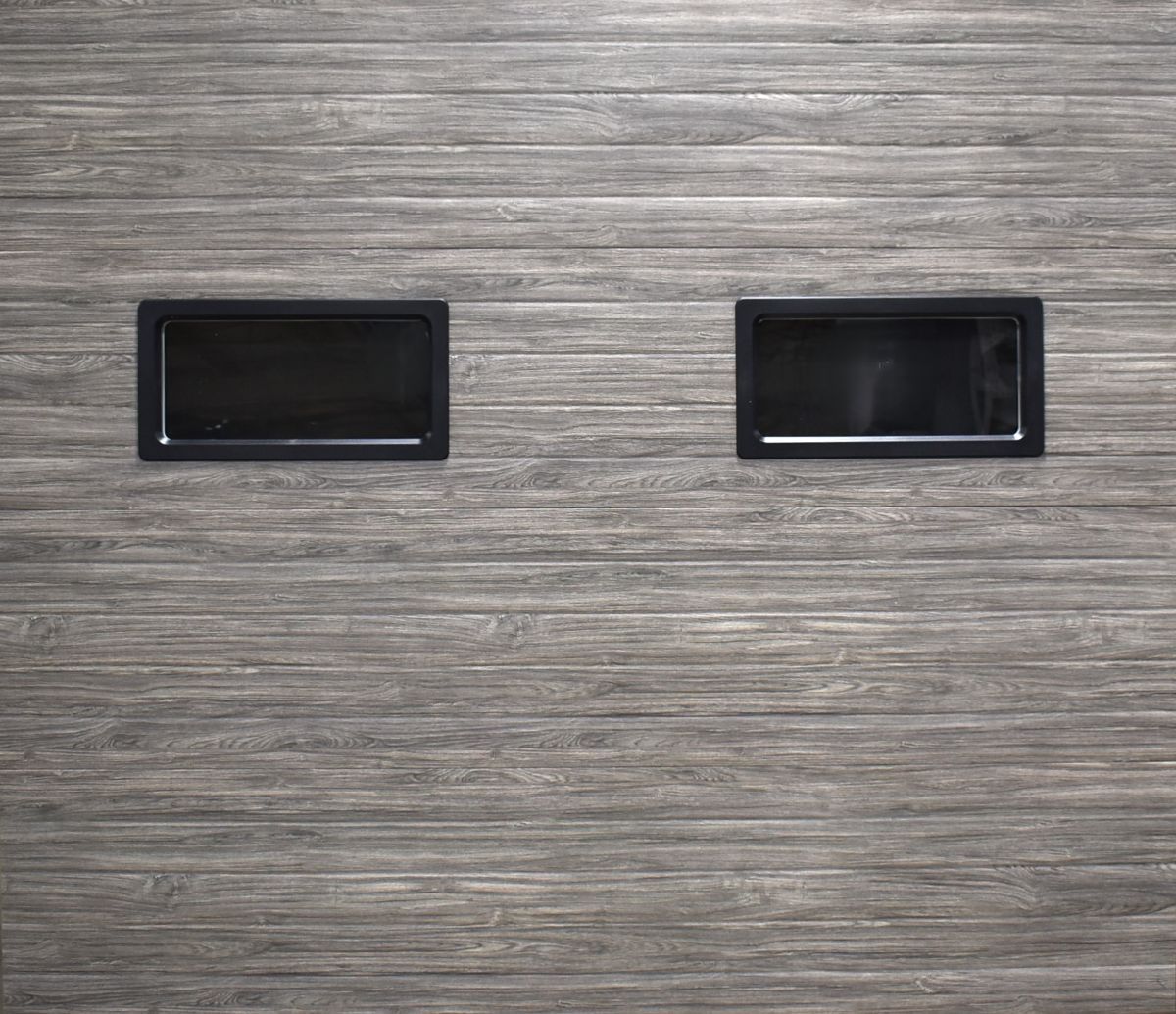Two black recessed handles on a gray wood-grain panel.