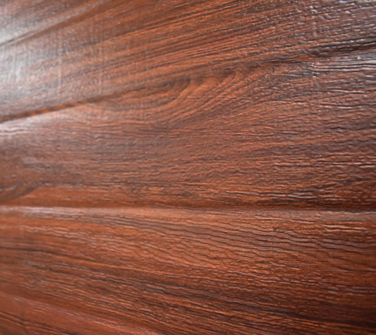 Close-up of rich brown wood grain paneling with horizontal lines.