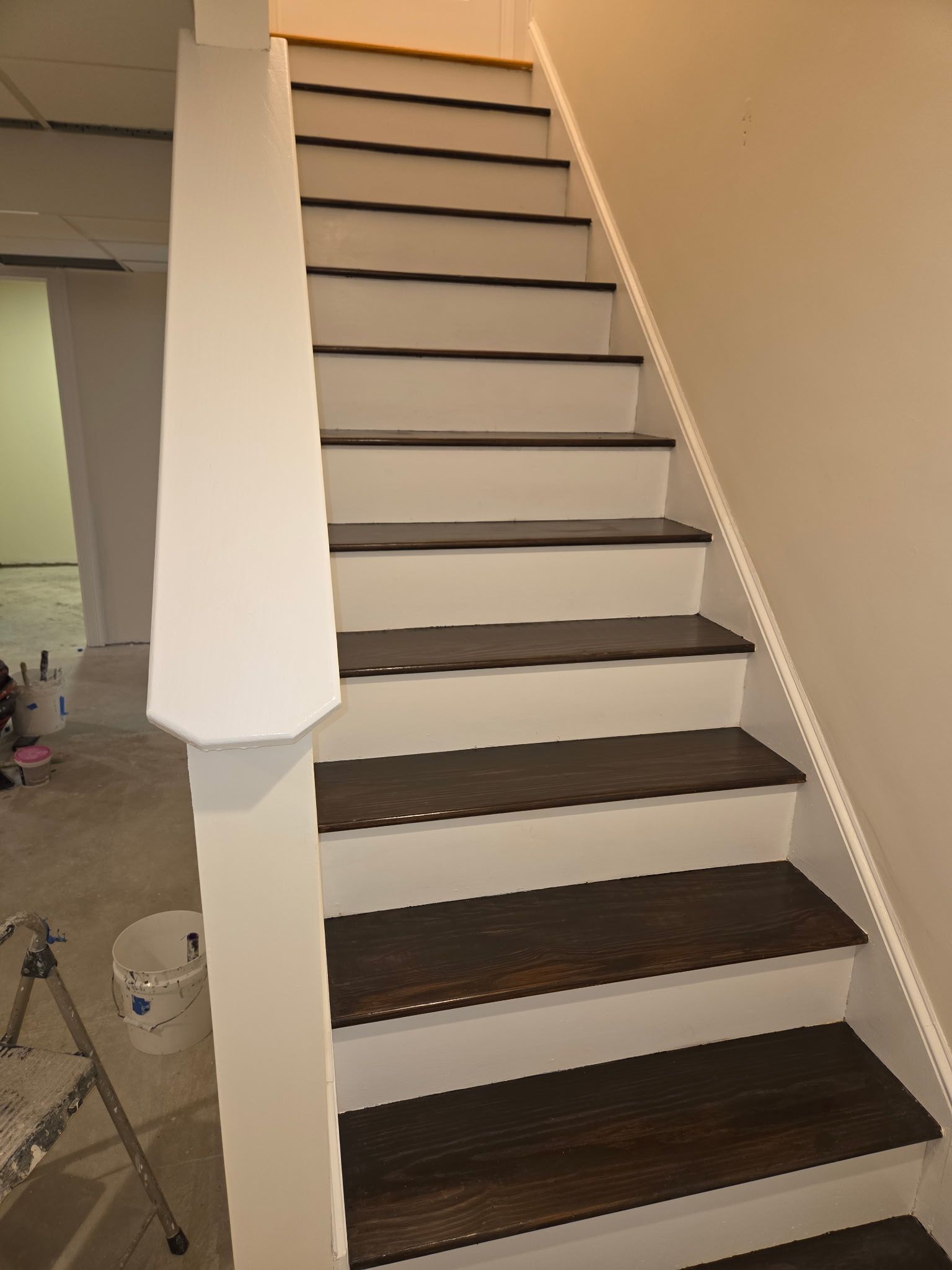 Wooden staircase with white risers and dark brown treads.