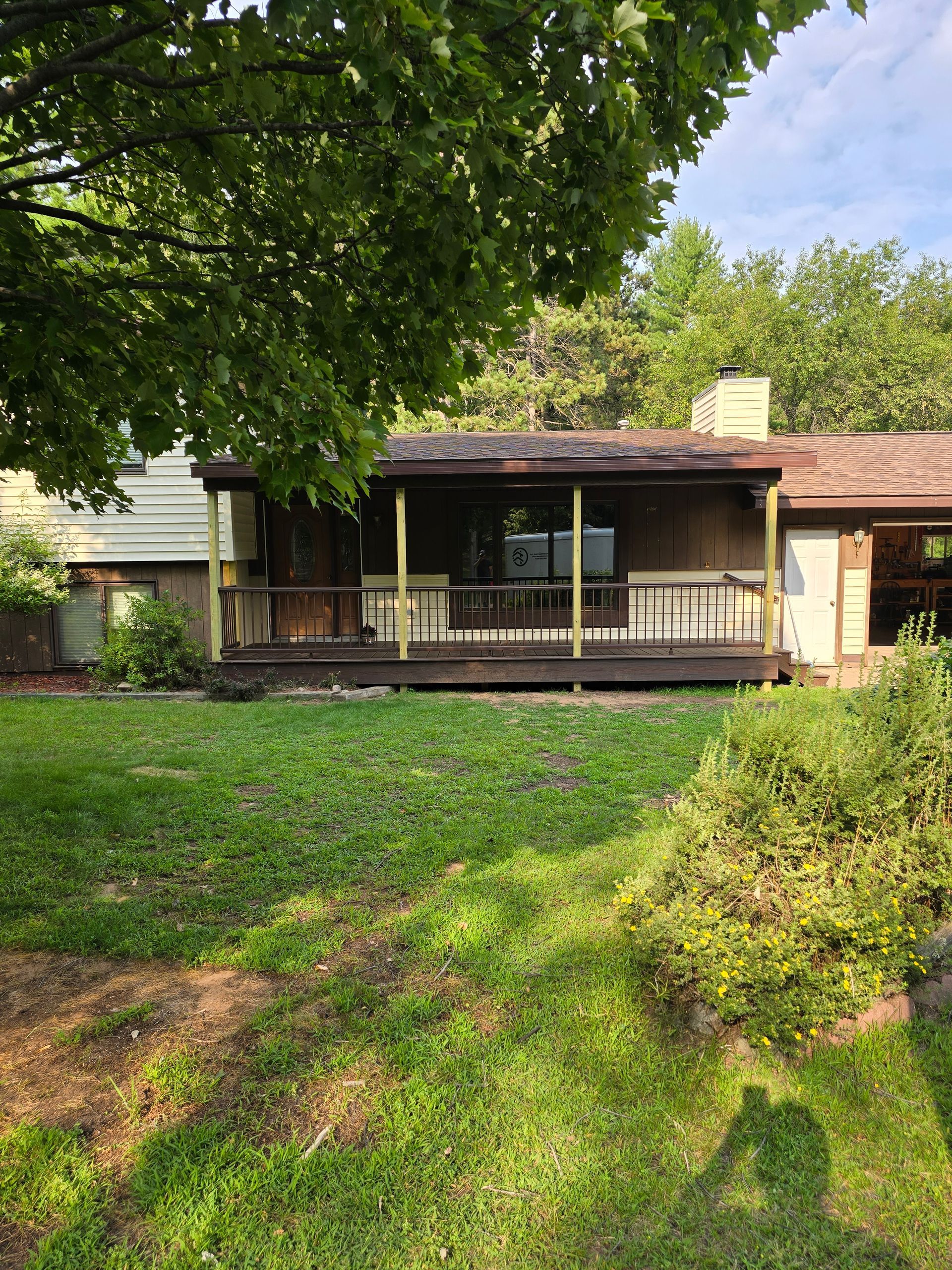 A house with a porch and a large lawn in front of it