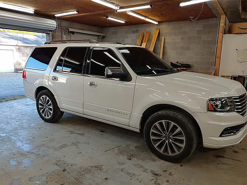 White Lincoln Navigator SUV parked inside a garage.