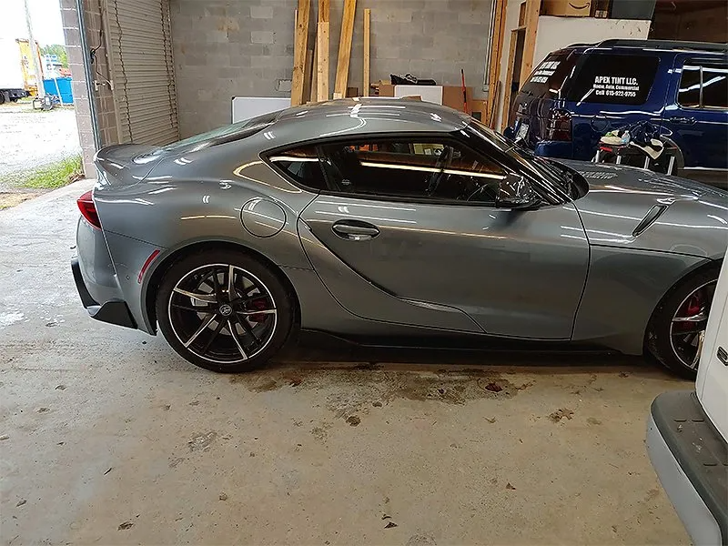 Gray Toyota Supra sports car parked in a garage.
