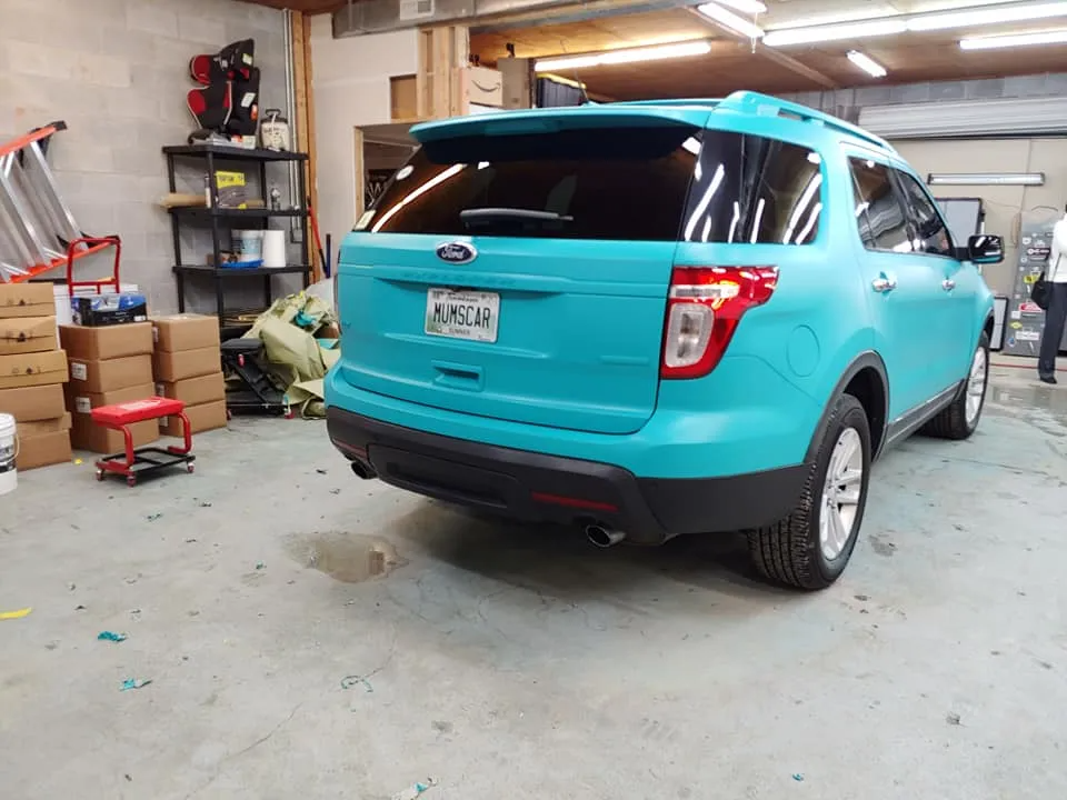 Turquoise Ford Explorer in a garage.