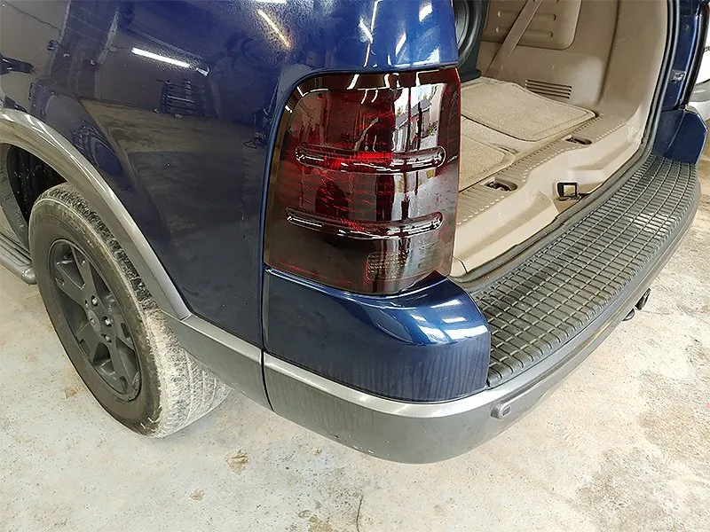 Dark blue SUV rear with tinted taillight and black bumper.