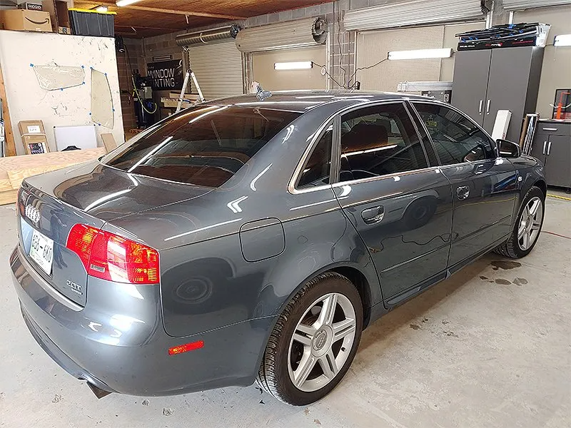 Gray Audi sedan with tinted windows parked in a garage.
